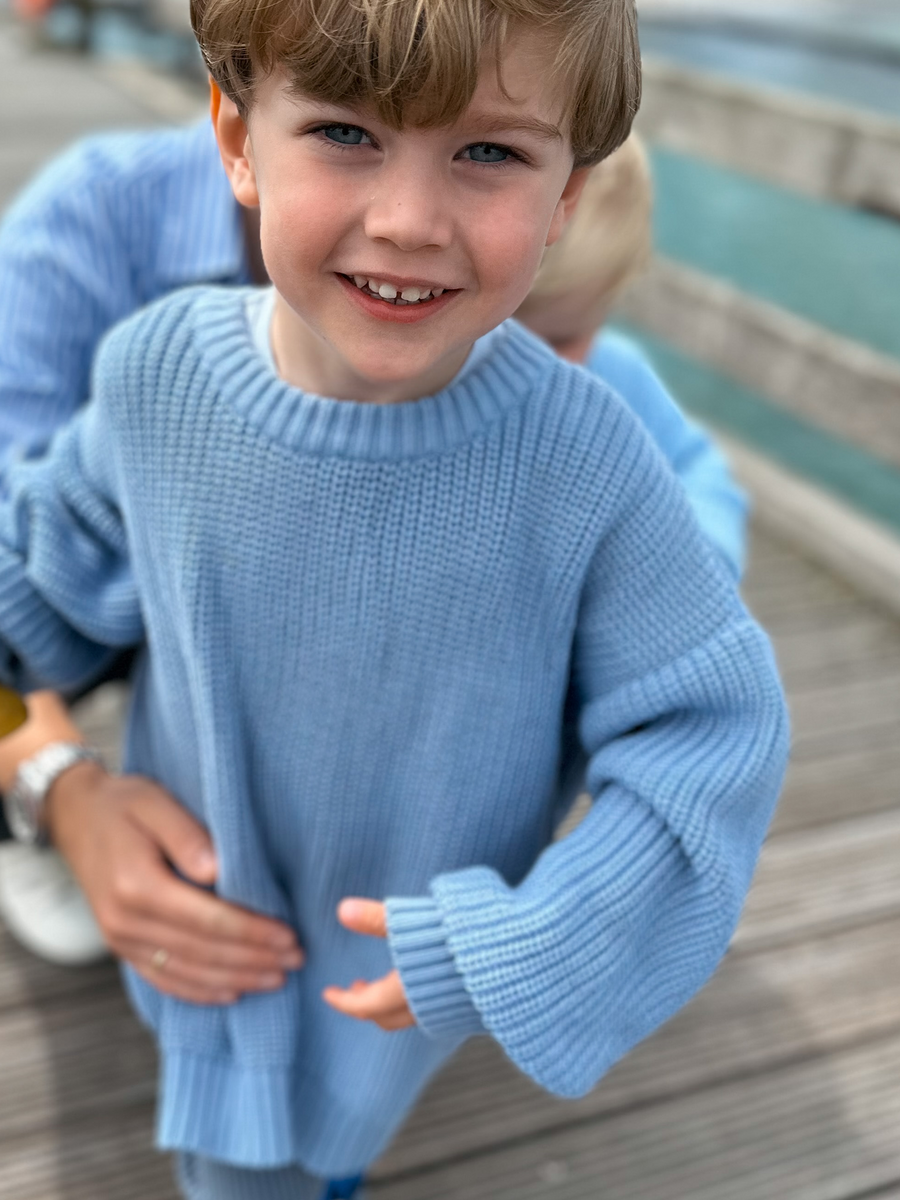 Junge in blauem Strickpullover Partnerlook mit Papa